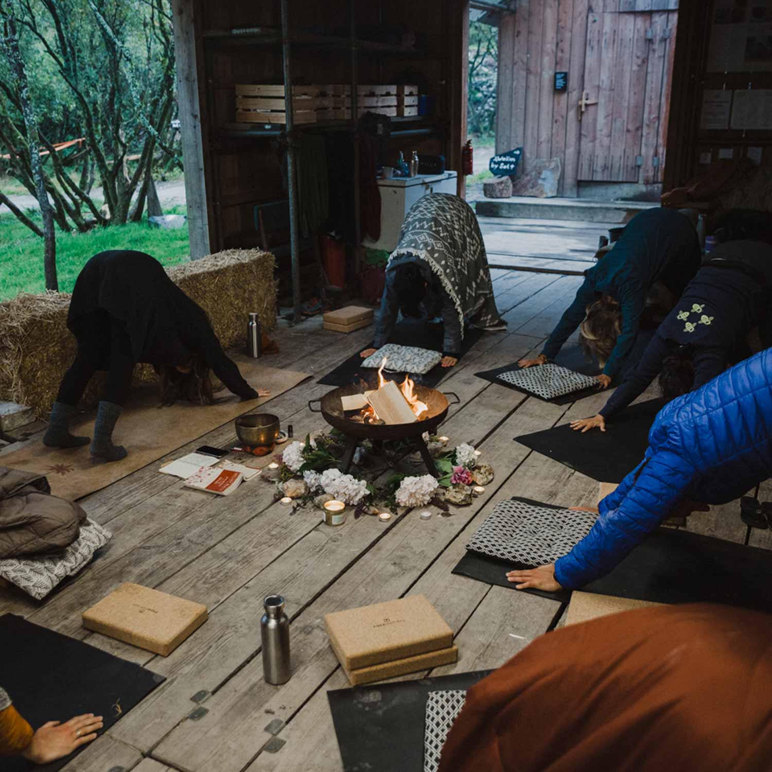 a yoga class around a fire at Kudhva, off grid campsite