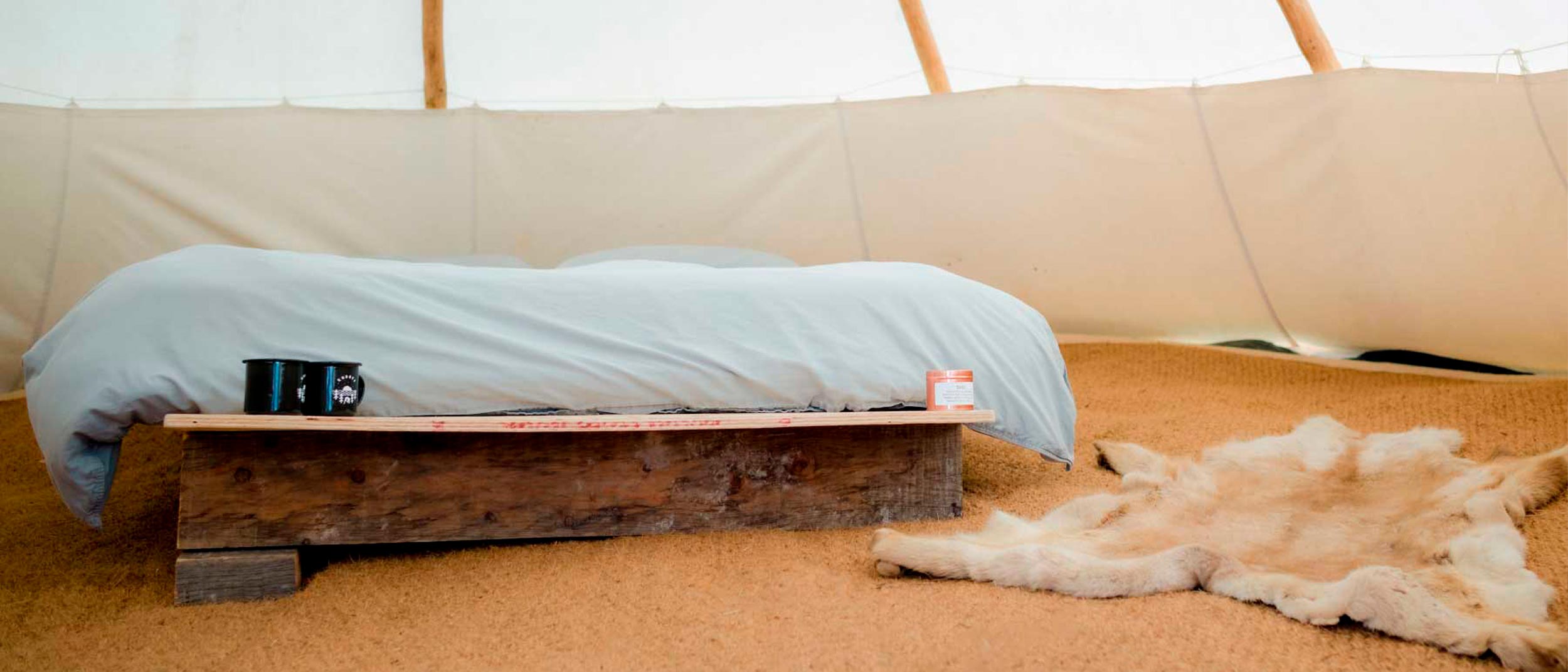 comfortable double bed in a tipi at Kudhva, sustainable glamping in Cornwall